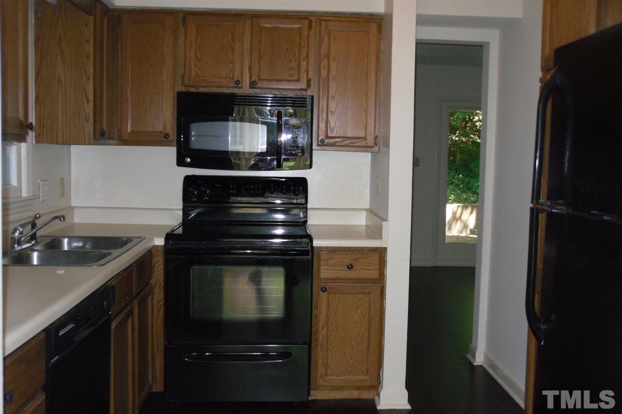 1316 Dylan Heath Court Raleigh, NC 27608 - Photo 8 of 17 a kitchen with a stove and a microwave