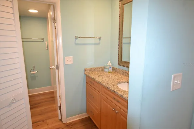 a bathroom with a granite countertop sink and a mirror