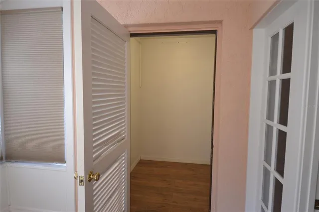 a view of a hallway with wooden floor and closet