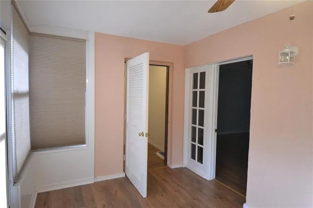 a view of a hallway with wooden floor and cabinet