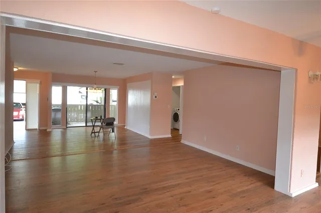 a view of empty room with wooden floor and seating space