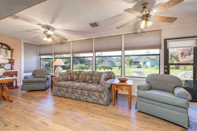 a living room with furniture and a large window with wooden floor