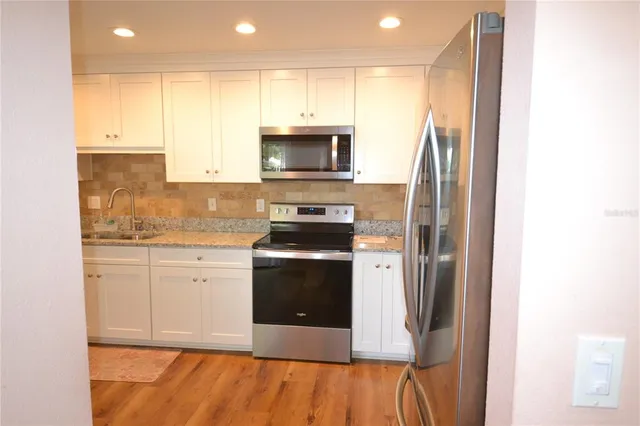 a kitchen with stainless steel appliances granite countertop a stove a sink and a refrigerator