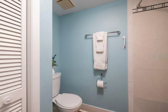 a white toilet sitting next to a shower curtain
