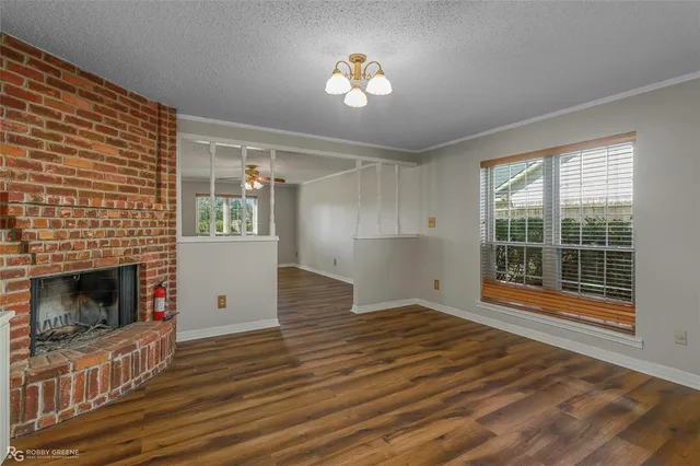 a view of empty room with wooden floor and fireplace