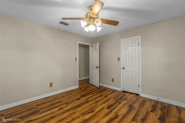 a view of a livingroom with wooden floor and a ceiling fan