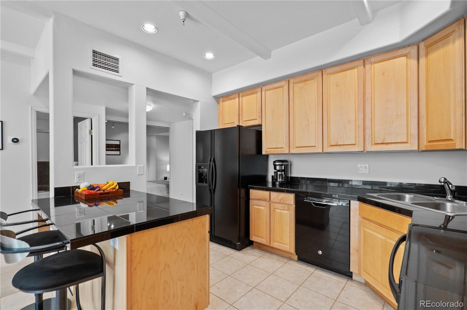 180 Cook Street, Unit 203 Denver, CO 80206 - Photo 11 of 44 a kitchen with stainless steel appliances granite countertop a refrigerator and a stove top oven