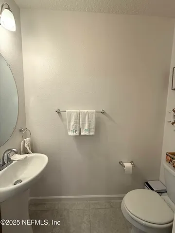 a bathroom with a toilet a sink and mirror