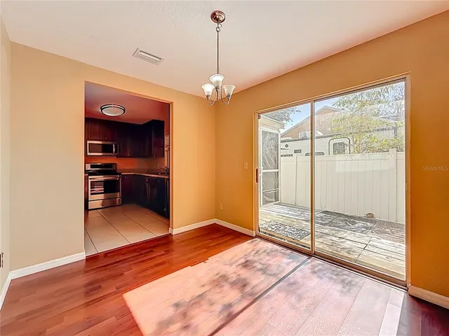 a bedroom with a large bed and wooden floor
