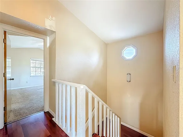 a view of a big room with windows and chandelier fan