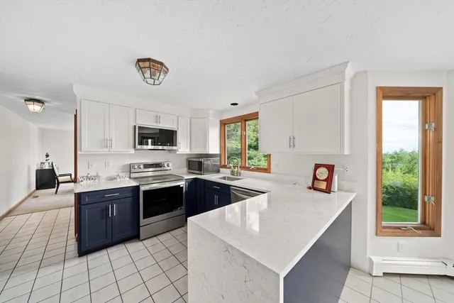 a kitchen with stainless steel appliances granite countertop a sink dishwasher stove top oven and cabinets