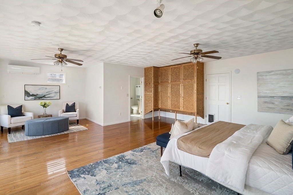 1 Spray Avenue Revere, MA 02151 - Photo 15 of 36 a spacious bedroom with a bed a couch and wooden floor