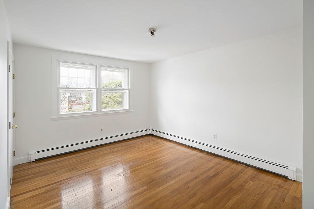 1 Spray Avenue Revere, MA 02151 - Photo 19 of 36 an empty room with wooden floor and windows