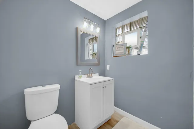 a bathroom with a toilet sink and mirror