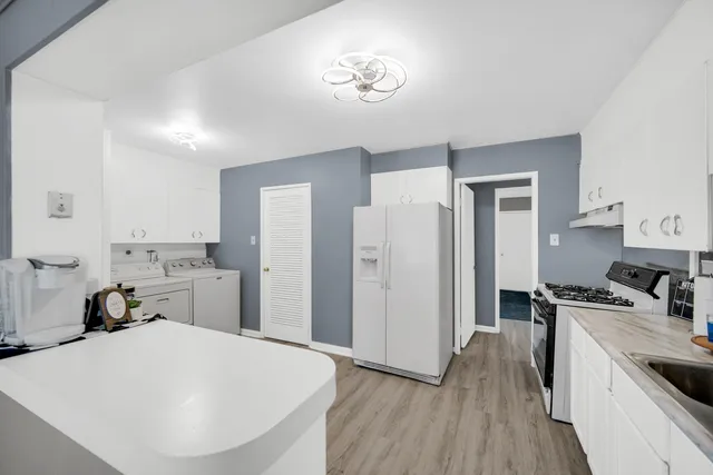 a kitchen with a refrigerator and a stove top oven