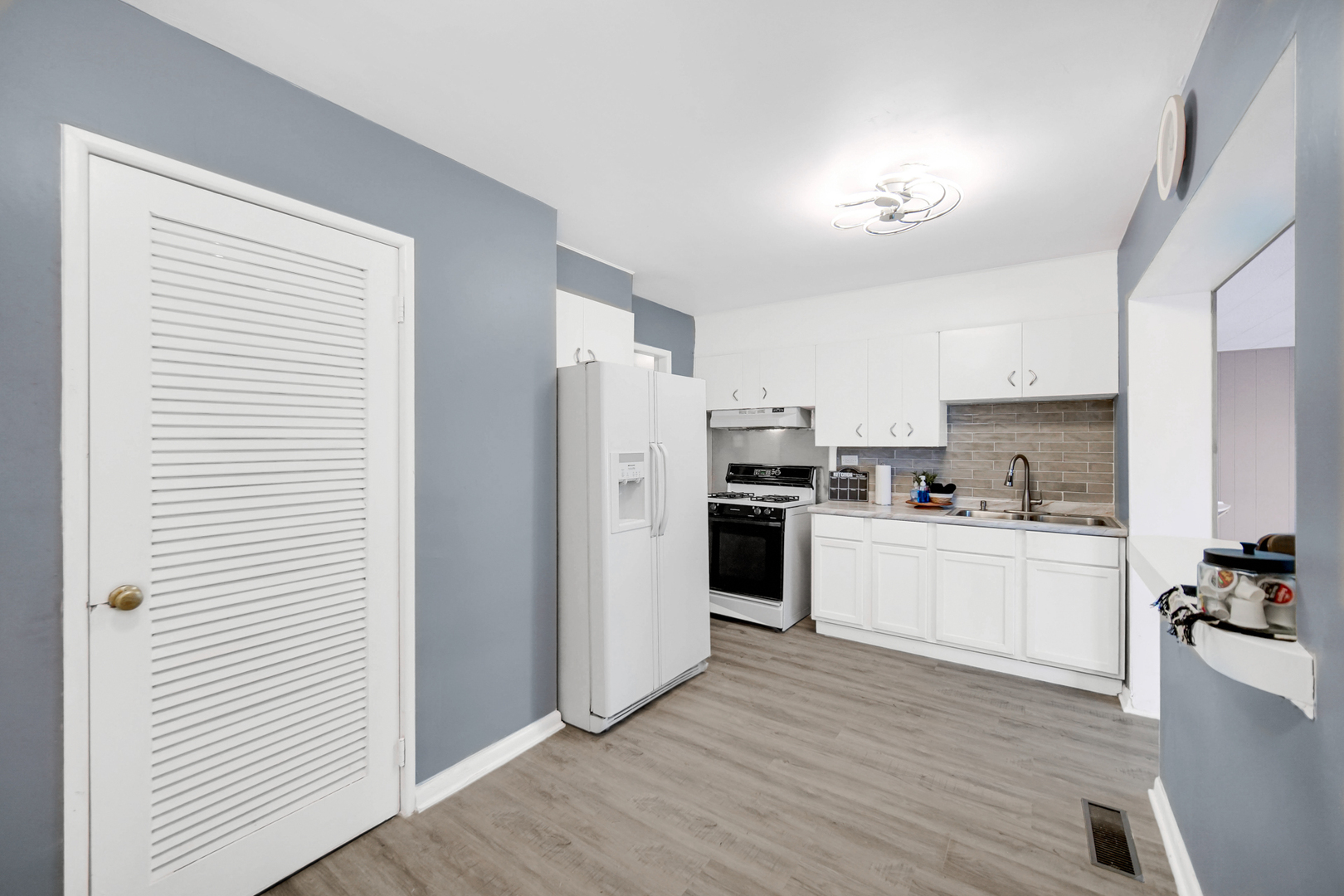 1455 Burnham Avenue Calumet City, IL 60409 - Photo 5 of 20 a kitchen with stainless steel appliances a refrigerator a stove a sink and white cabinets