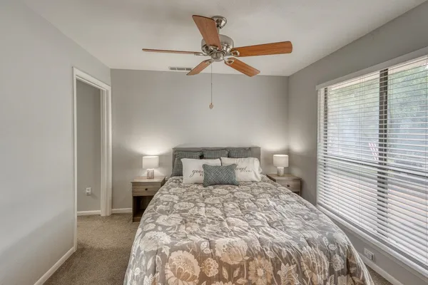 a bedroom with a large bed and a large window with the outer view