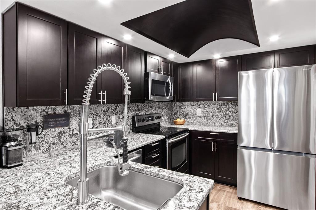 18040 Midway Road, Unit 103 Dallas, TX 75287 - Photo 7 of 38 a kitchen with stainless steel appliances granite countertop a sink stove and refrigerator