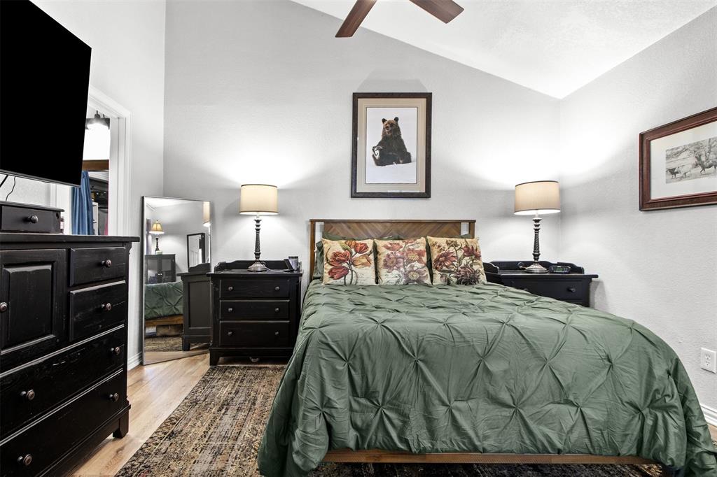 18040 Midway Road, Unit 103 Dallas, TX 75287 - Photo 10 of 37 a bedroom with a bed and a flat tv screen on a dresser