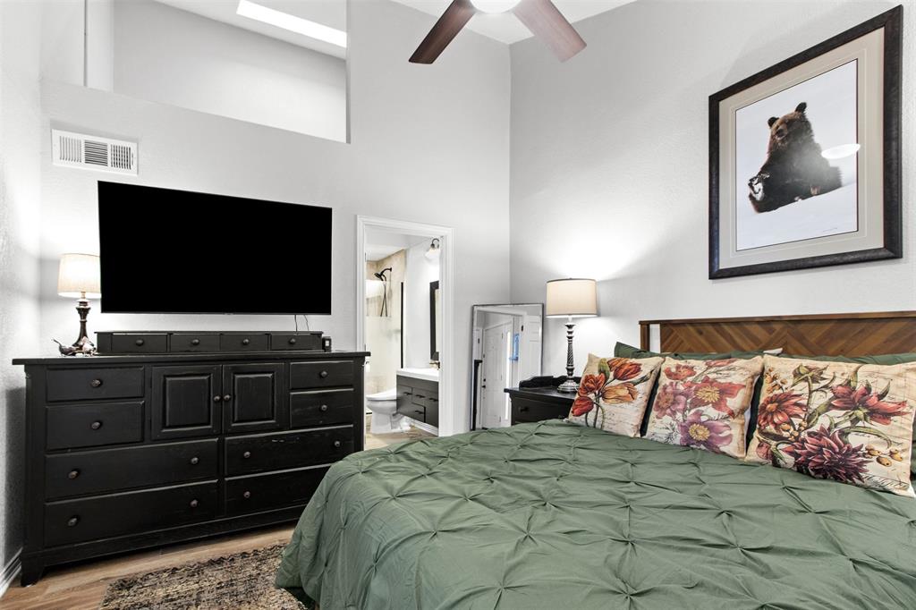 18040 Midway Road, Unit 103 Dallas, TX 75287 - Photo 12 of 38 a bedroom with a bed and a flat screen tv