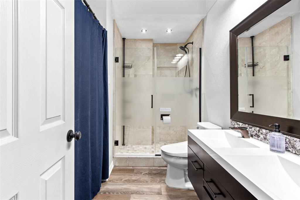 18040 Midway Road, Unit 103 Dallas, TX 75287 - Photo 12 of 37 a bathroom with a sink toilet double vanity and shower