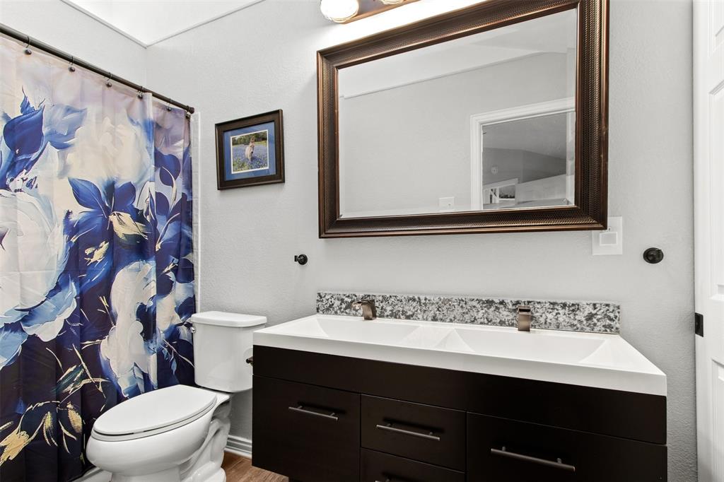 18040 Midway Road, Unit 103 Dallas, TX 75287 - Photo 20 of 38 a bathroom with a toilet sink and mirror