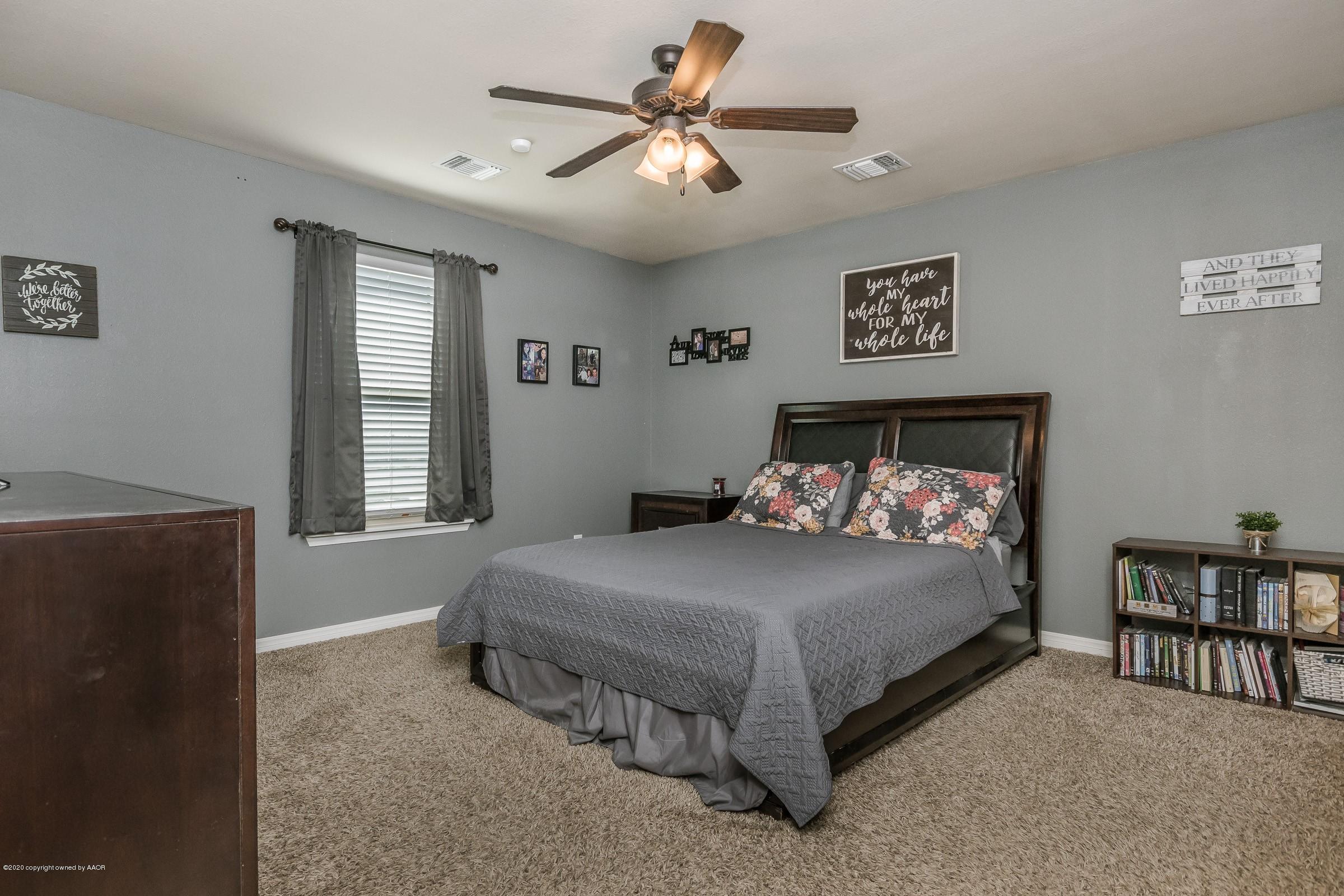 2808 Simkins Lane Amarillo, TX 79118 - Photo 8 of 20 a bedroom with a bed and a chandelier