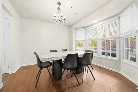 a view of a dining room with furniture wooden floor and chandelier