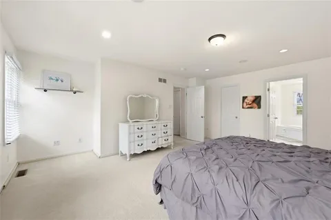 a bedroom with a bed and a refrigerator