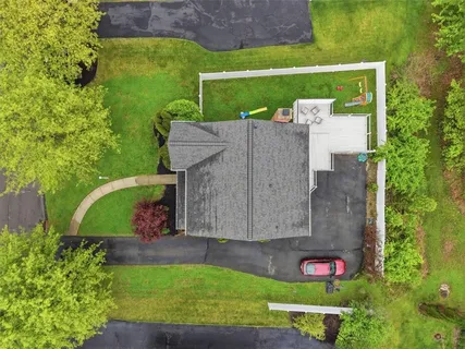 an aerial view of a houses with a yard and lake view