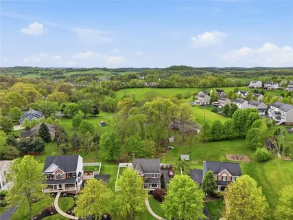 an aerial view of a house with a garden and lake view