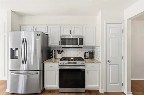 a kitchen with stainless steel appliances granite countertop a refrigerator stove and microwave