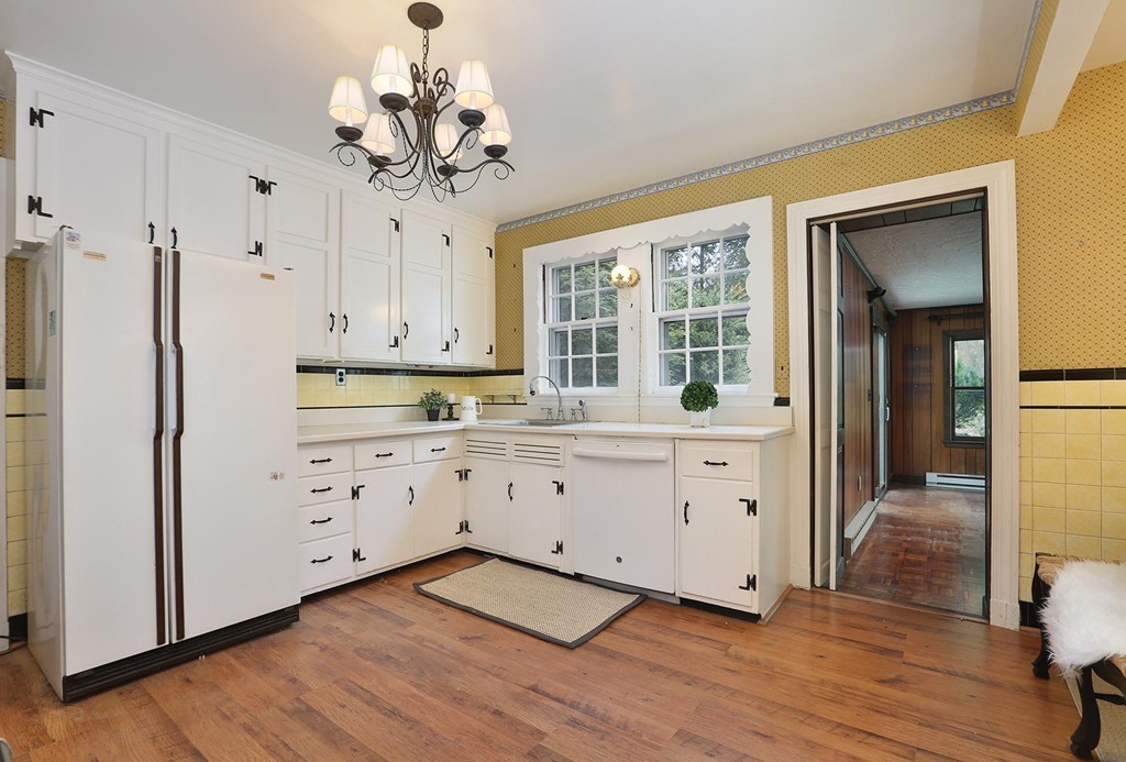 119 Walnut Hill Road Brookline, MA 02467 - Photo 4 of 12 a kitchen with white cabinets and wooden floor