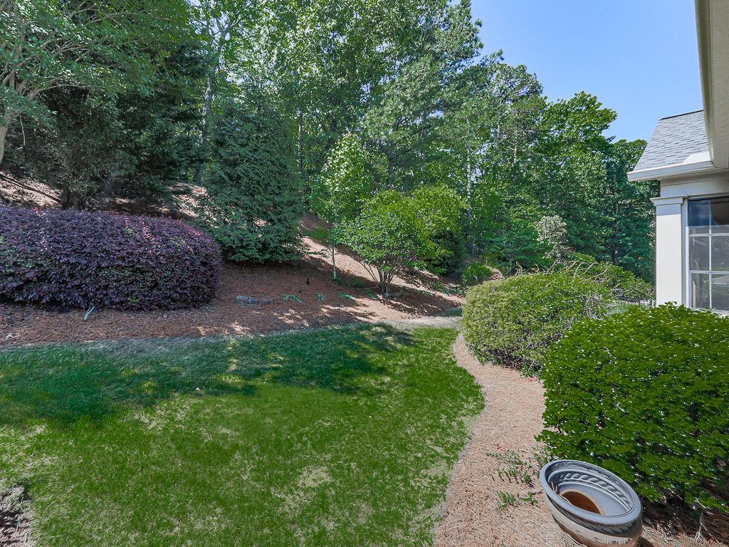 626 Laurel Crossing Canton, GA 30114 - Photo 46 of 77 a view of a garden with lawn chairs under an umbrella