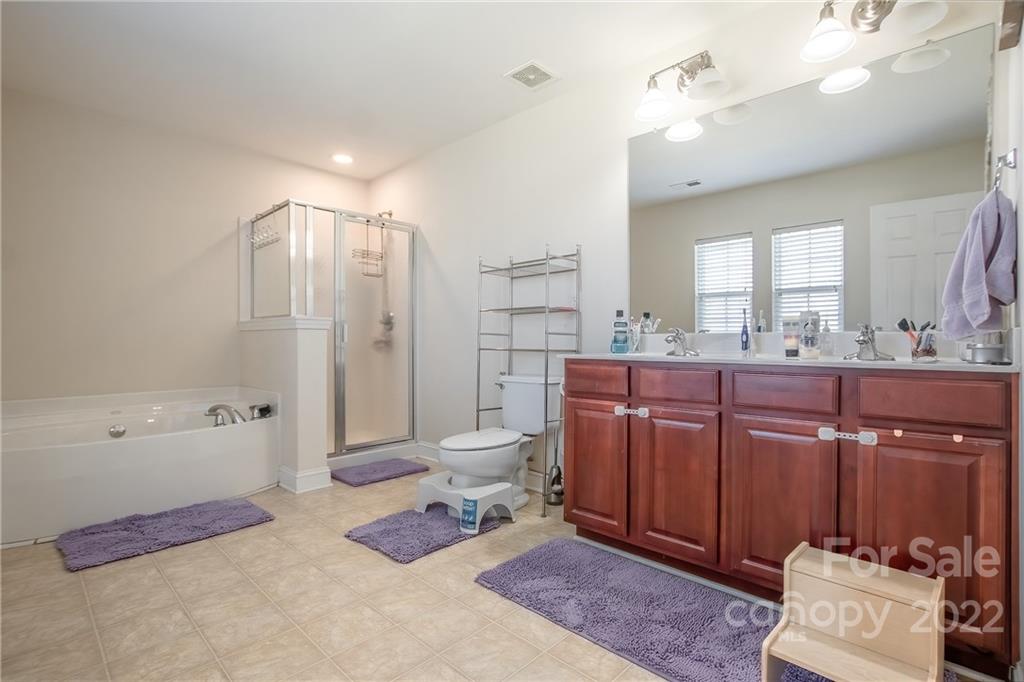 6809 Evanton Loch Road Charlotte, NC 28278 - Photo 14 of 30 a spacious bathroom with a granite countertop sink a toilet and shower