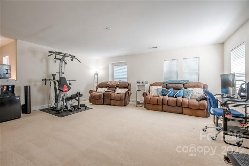 6809 Evanton Loch Road Charlotte, NC 28278 - Photo 19 of 30 a bedroom with furniture and a gym equipment