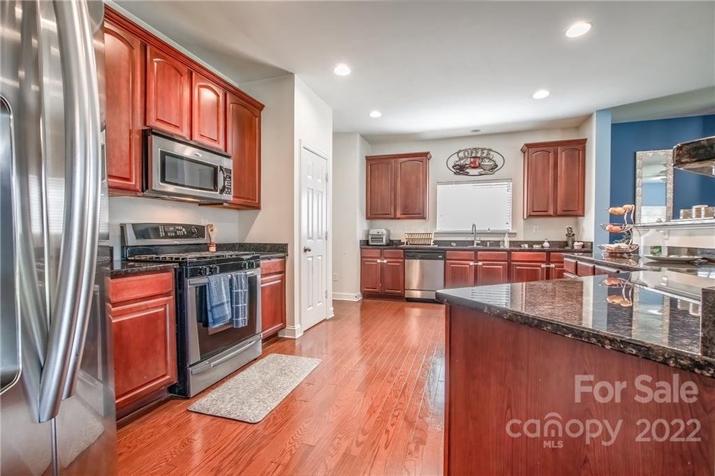 6809 Evanton Loch Road Charlotte, NC 28278 - Photo 7 of 30 a kitchen with stainless steel appliances granite countertop a stove a sink and a microwave