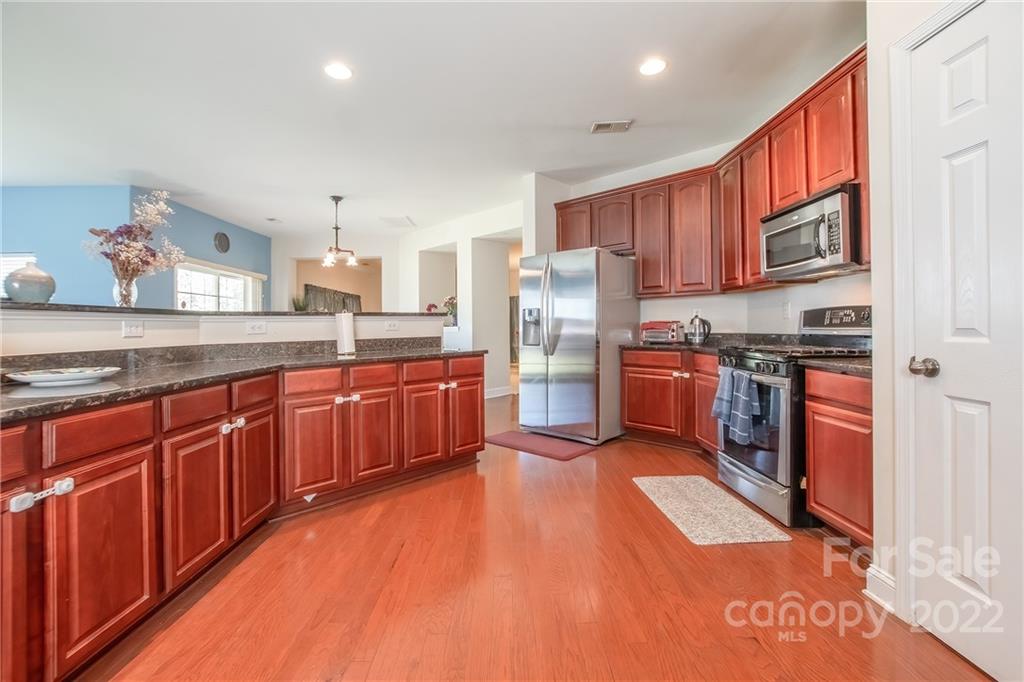 6809 Evanton Loch Road Charlotte, NC 28278 - Photo 8 of 30 a large kitchen with stainless steel appliances granite countertop a refrigerator a stove top oven a sink and dishwasher