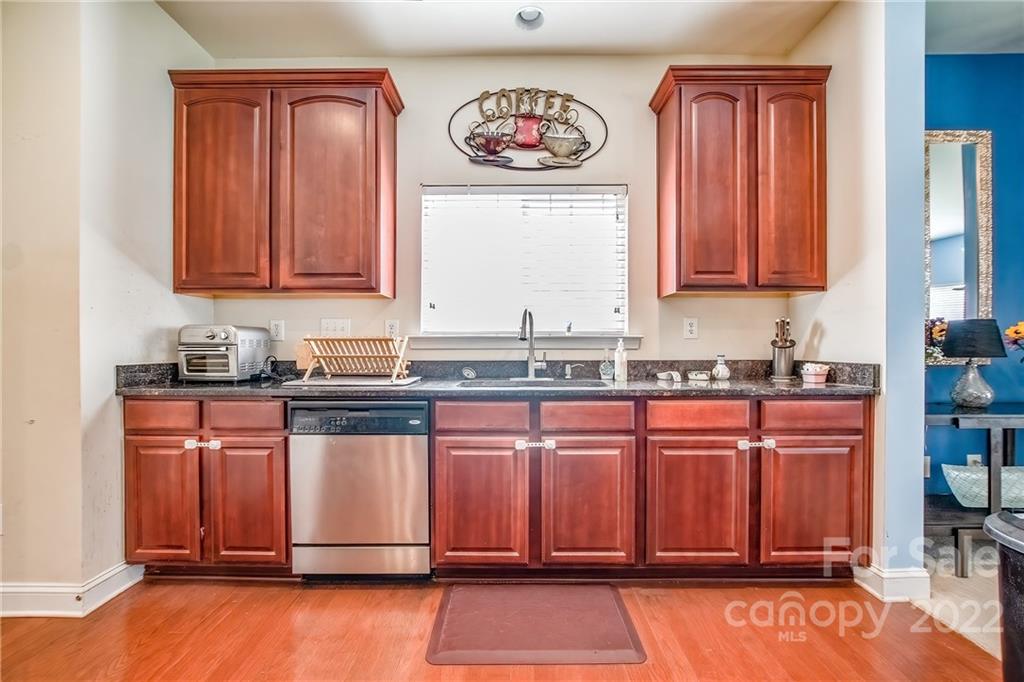 6809 Evanton Loch Road Charlotte, NC 28278 - Photo 9 of 30 a kitchen with stainless steel appliances granite countertop wooden cabinets a sink and a window