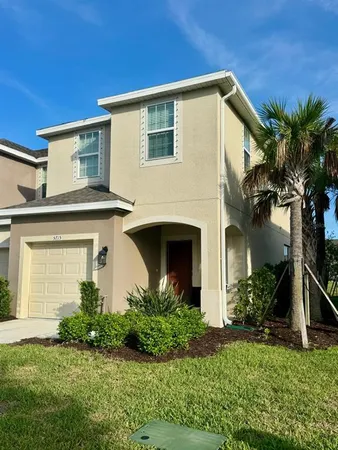 a front view of a house with a garden and plants