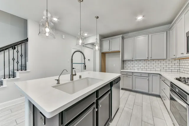 a kitchen with a sink chandelier and refrigerator