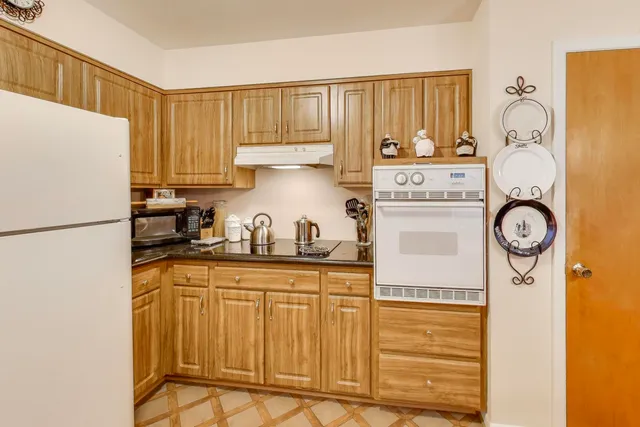 a kitchen with stainless steel appliances granite countertop a refrigerator a stove a sink and a cabinets