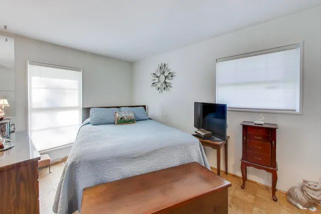a bedroom with a bed and a flat tv screen on the dresser