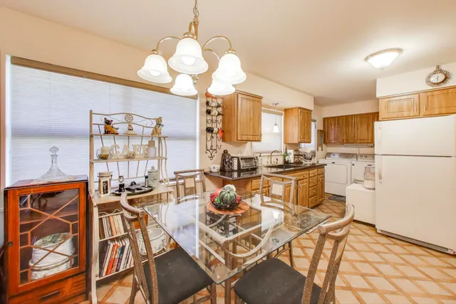 a view of a dining room with furniture a chandelier and wooden floor