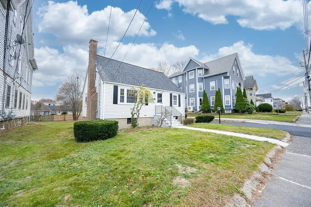 a view of a house with a big yard and a large tree