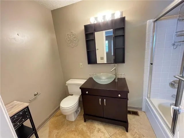 a bathroom with a toilet a sink and mirror