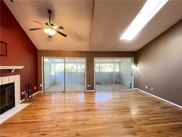 a view of an empty room with window and wooden floor