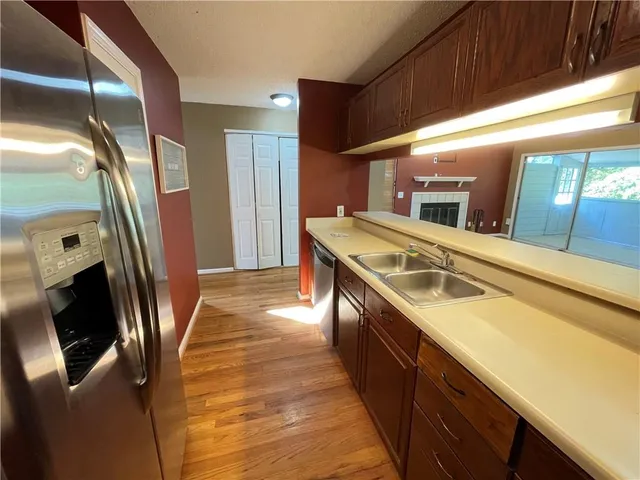 a kitchen with stainless steel appliances granite countertop a sink a stove and a refrigerator