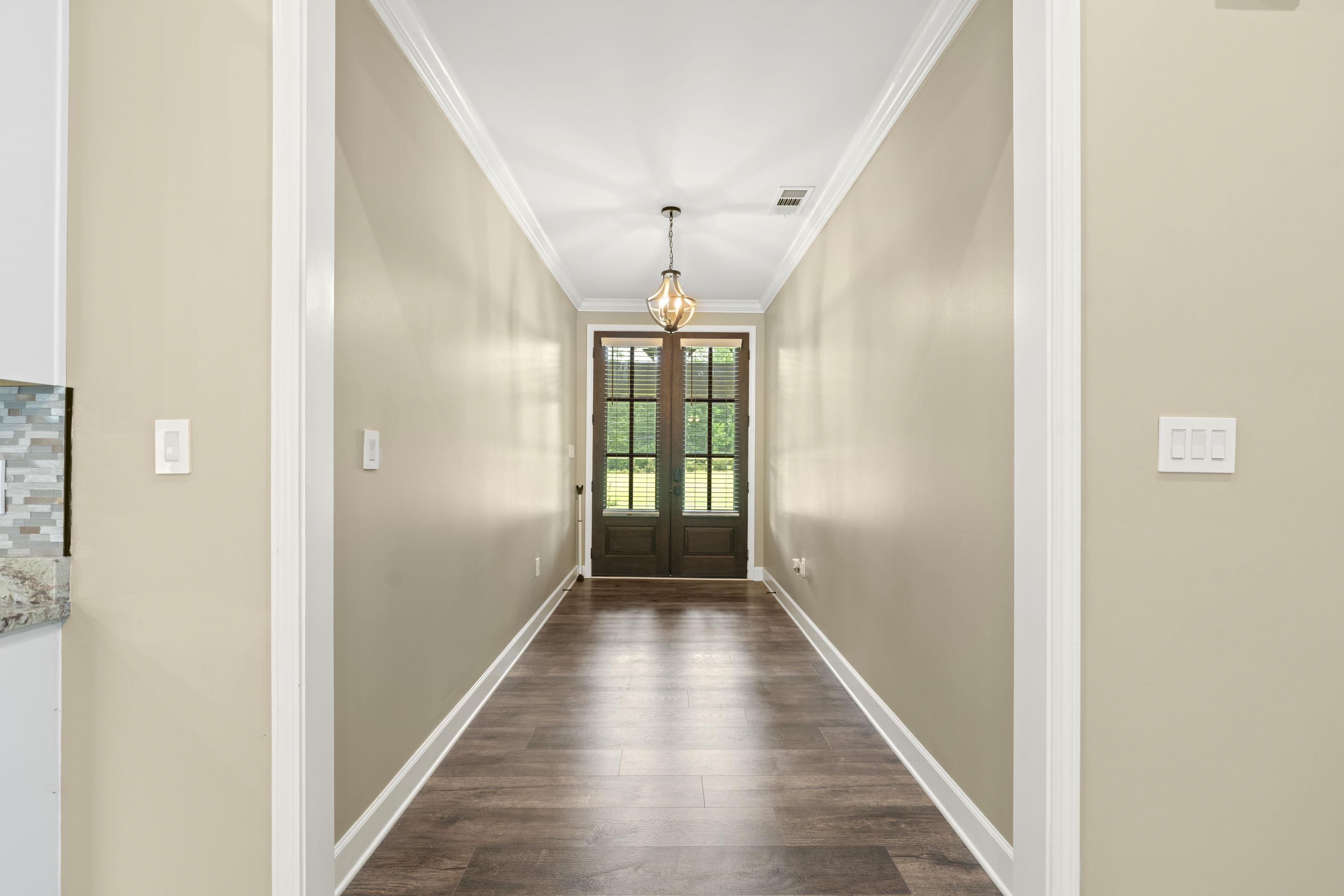 2295 Tomlin Road Somerville, TN 38068 - Photo 5 of 38 Doorway with ornamental molding, dark wood finished floors, and a chandelier