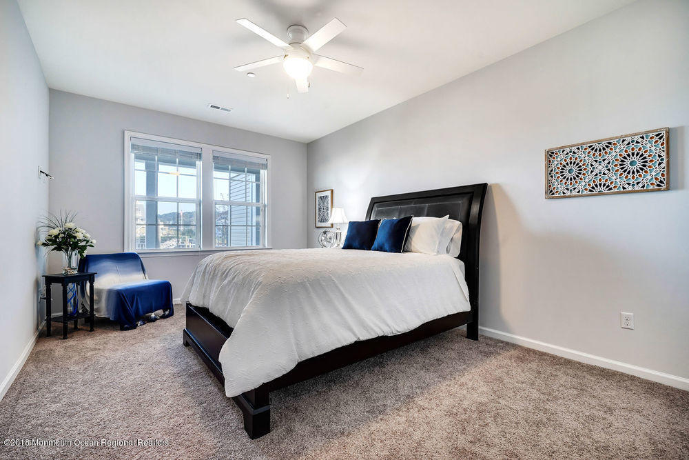 11 Lighthouse Point Road, Unit 601 Highlands, NJ 07732 - Photo 12 of 79 a bedroom with a large bed and a chandelier